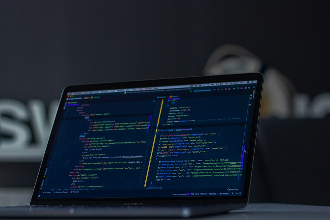 programmer coding on laptop